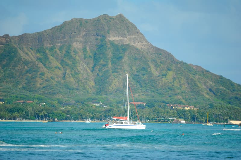 A catamaran under sail off Waikīkī with Diamond Head behind