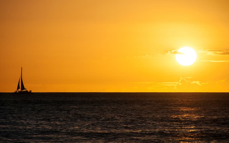 A sailboat silhouetted against the sunset off the leeward coast near Ko Olina